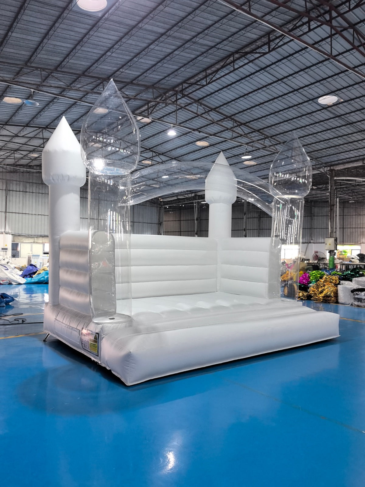 Colorful Balloon Pillar Bounce House by Aura Luxury Rental Ltd with vibrant inflatable arches and spacious jumping area.