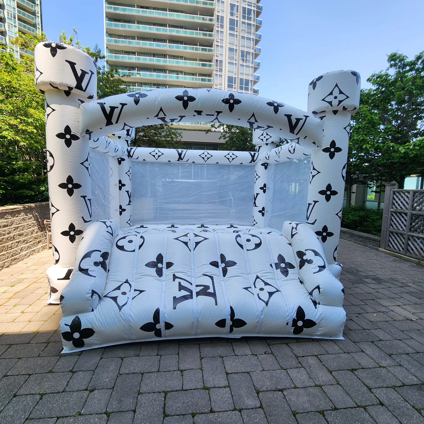 14ft Louis Vuitton themed bounce house by Aura Luxury Rental Ltd with colorful fabric and vibrant Louis Vuitton logo details.