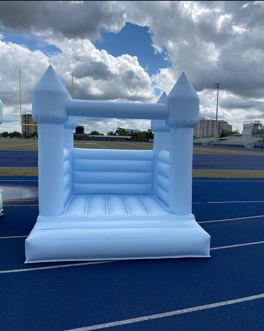 Baby blue bounce house from Aura Luxury Rental Ltd with colorful slides and inflatable play area for kids' outdoor fun.