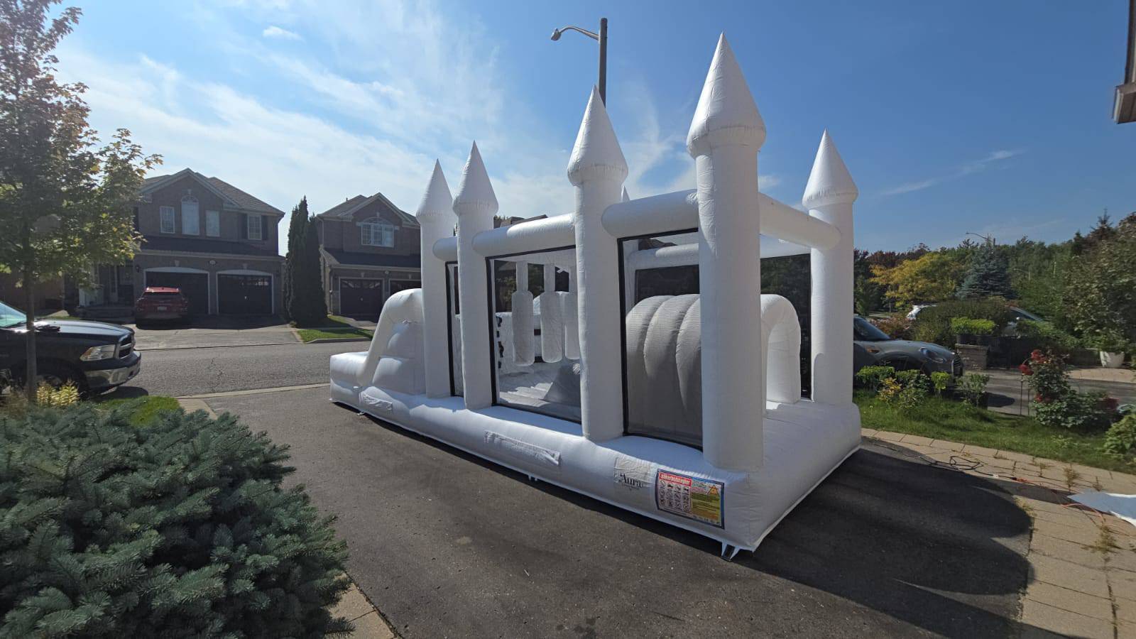 Aura Luxury Rental Ltd obstacle course with ball pit and waterslide, featuring colorful inflatable play structures for kids.