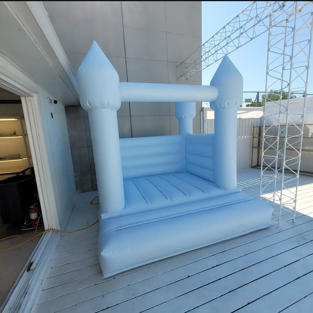 Baby blue bounce house from Aura Luxury Rental Ltd with colorful slides and inflatable design for kids' outdoor fun.