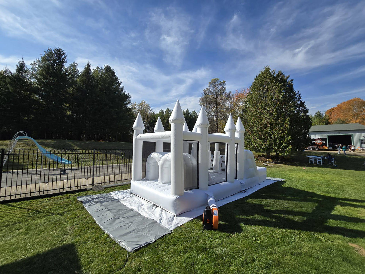 Colorful obstacle course with ball pit and waterslide for kids, designed by Aura Luxury Rental Ltd, featuring vibrant play elements.