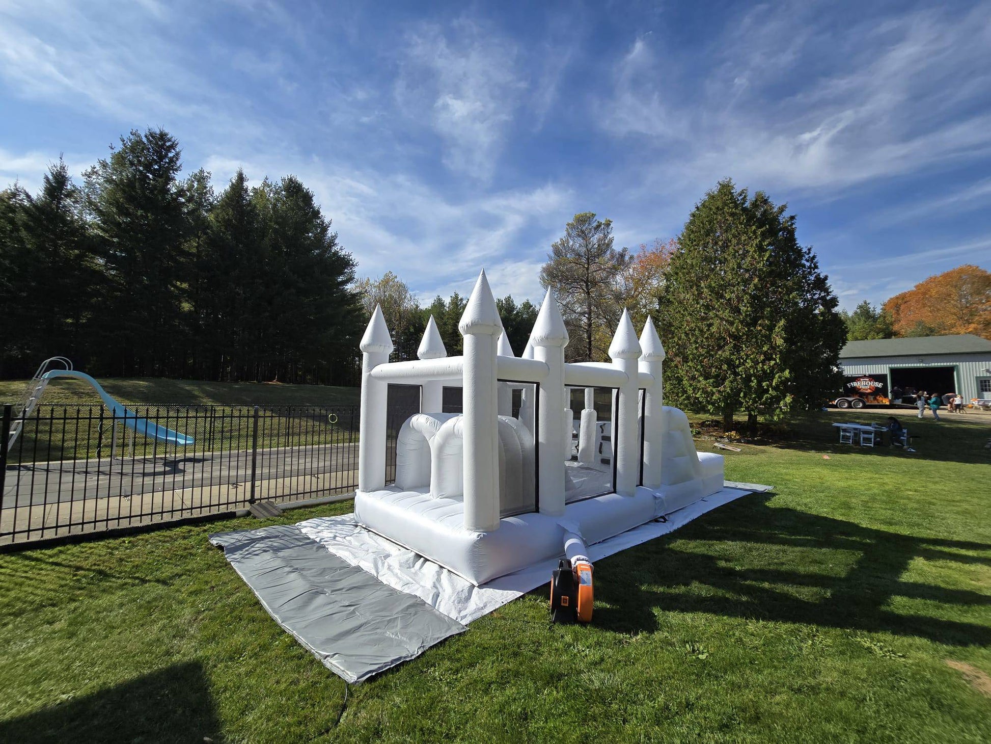 Colorful obstacle course with ball pit and waterslide for kids, designed by Aura Luxury Rental Ltd, featuring vibrant play elements.
