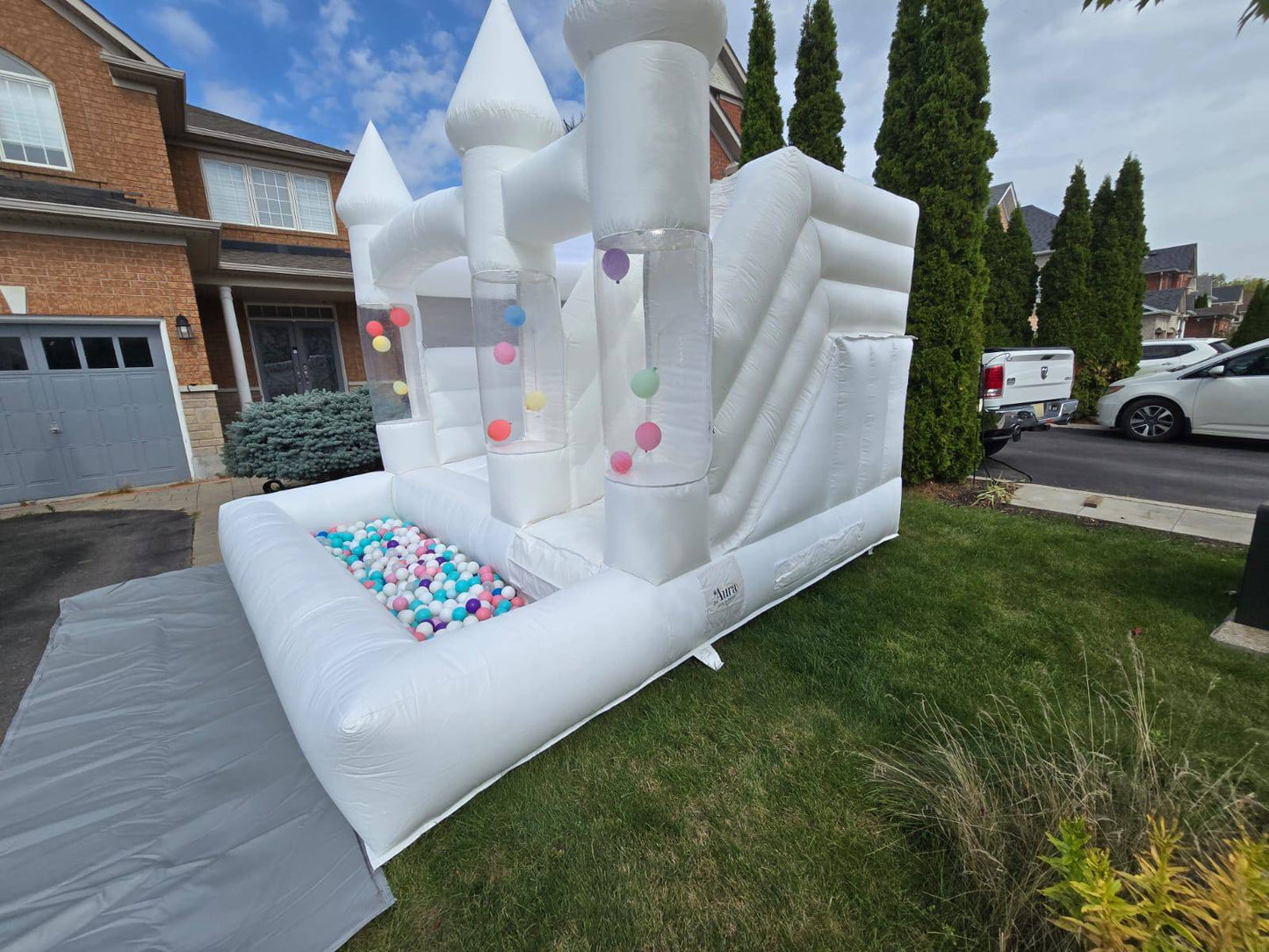 White balloon pillar castle with slide and ballpit for kids, designed by Aura Luxury Rental Ltd.