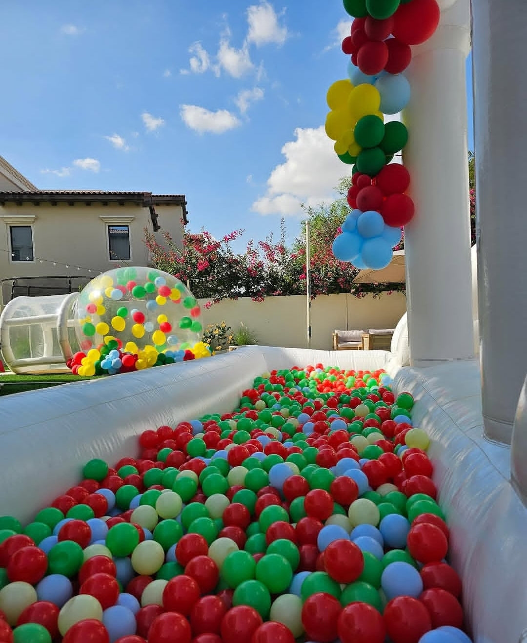 White double slide bouncy castle with ballpit from Aura Luxury Rental Ltd, featuring vibrant slides and a spacious play area.