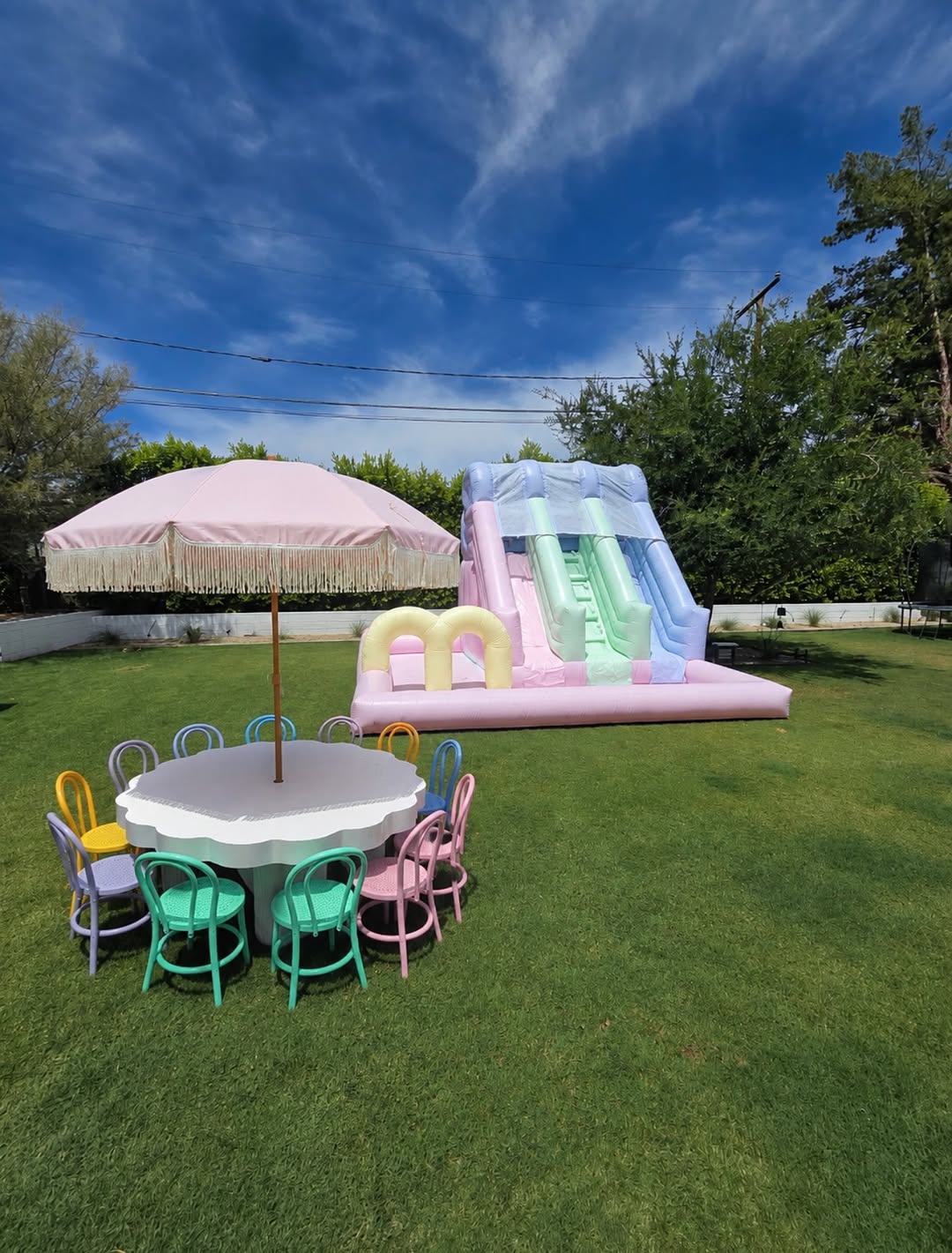 Colorful rainbow waterslide from Aura Luxury Rental Ltd, featuring vibrant slides and water features for outdoor fun.