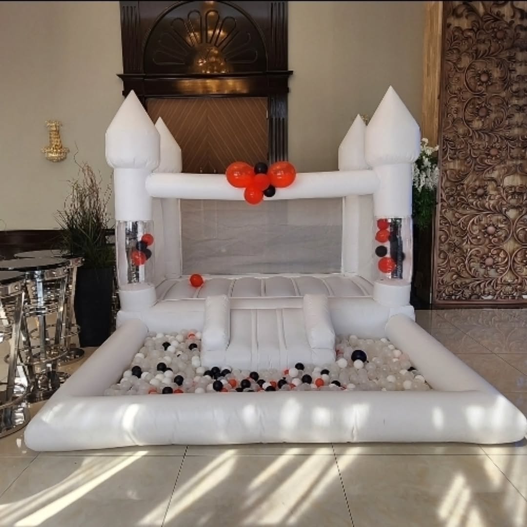 Colorful mini bouncy castle with slide and ballpit from Aura Luxury Rental Ltd, perfect for children's outdoor play.